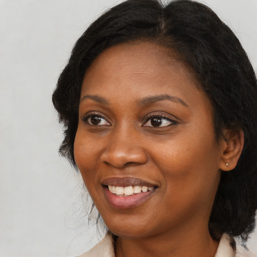 Joyful black young-adult female with medium  brown hair and brown eyes