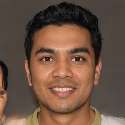 Joyful latino young-adult male with short  black hair and brown eyes