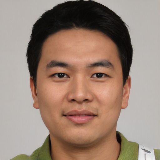 Joyful asian young-adult male with short  black hair and brown eyes