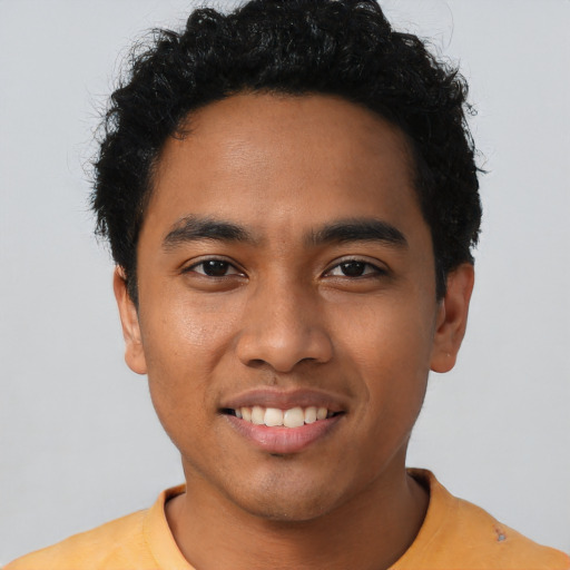 Joyful latino young-adult male with short  black hair and brown eyes