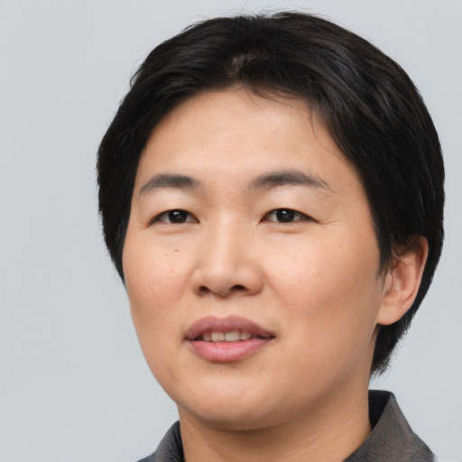 Joyful asian young-adult female with medium  black hair and brown eyes