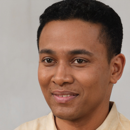 Joyful latino young-adult male with short  black hair and brown eyes