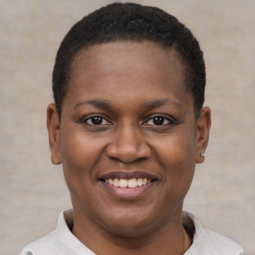 Joyful black young-adult female with short  black hair and brown eyes