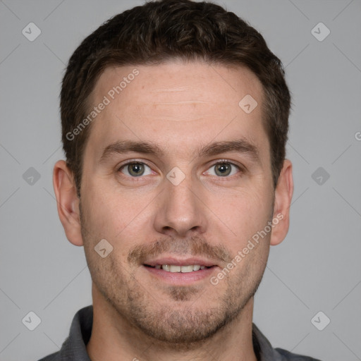 Joyful white young-adult male with short  brown hair and grey eyes