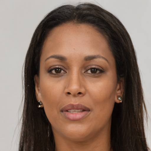 Joyful black adult female with long  brown hair and brown eyes