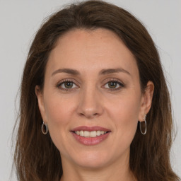 Joyful white adult female with long  brown hair and grey eyes