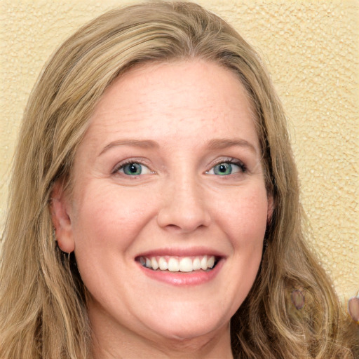 Joyful white adult female with long  brown hair and blue eyes