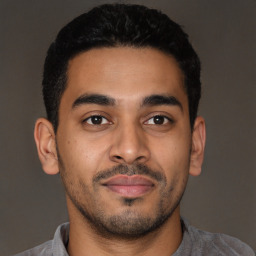 Joyful latino young-adult male with short  brown hair and brown eyes