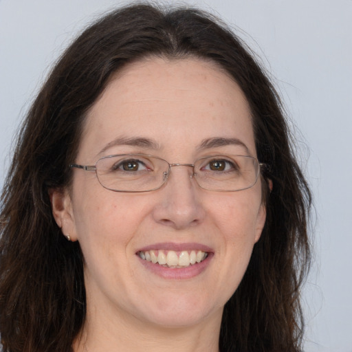 Joyful white adult female with long  brown hair and grey eyes