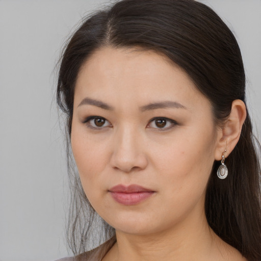Joyful asian young-adult female with long  brown hair and brown eyes