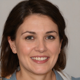 Joyful white adult female with medium  brown hair and brown eyes