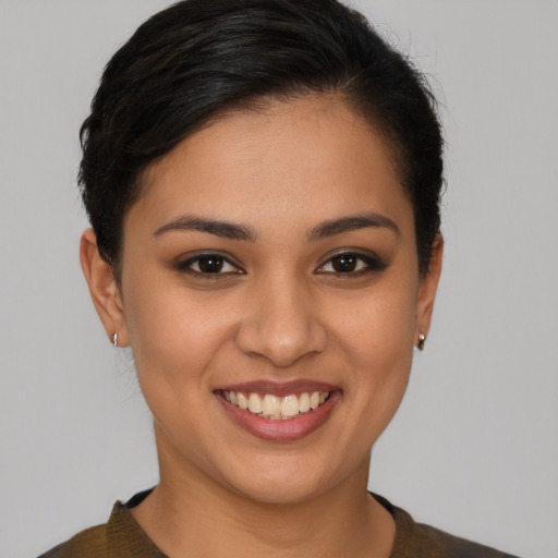Joyful latino young-adult female with short  brown hair and brown eyes
