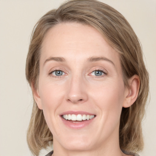 Joyful white young-adult female with medium  brown hair and green eyes