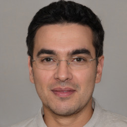 Joyful white adult male with short  black hair and brown eyes