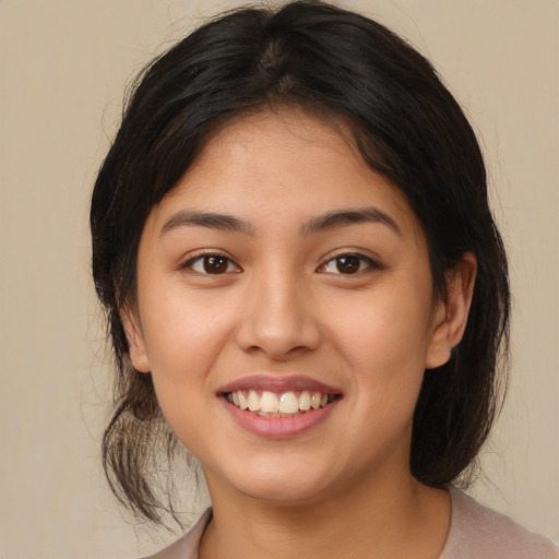 Joyful latino young-adult female with medium  brown hair and brown eyes