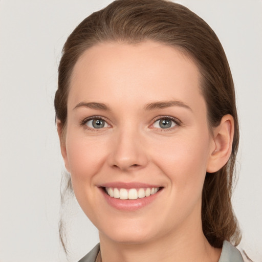 Joyful white young-adult female with medium  brown hair and grey eyes