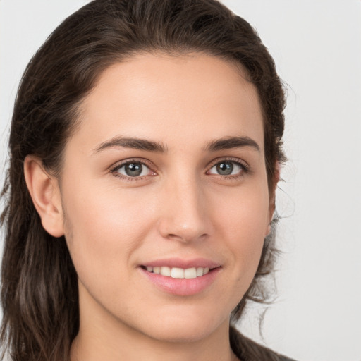 Joyful white young-adult female with long  brown hair and brown eyes