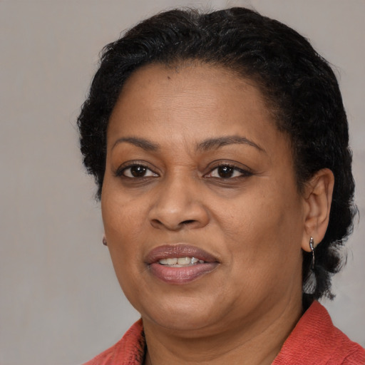 Joyful black adult female with medium  brown hair and brown eyes
