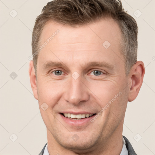 Joyful white adult male with short  brown hair and grey eyes