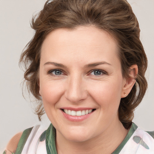 Joyful white young-adult female with medium  brown hair and green eyes