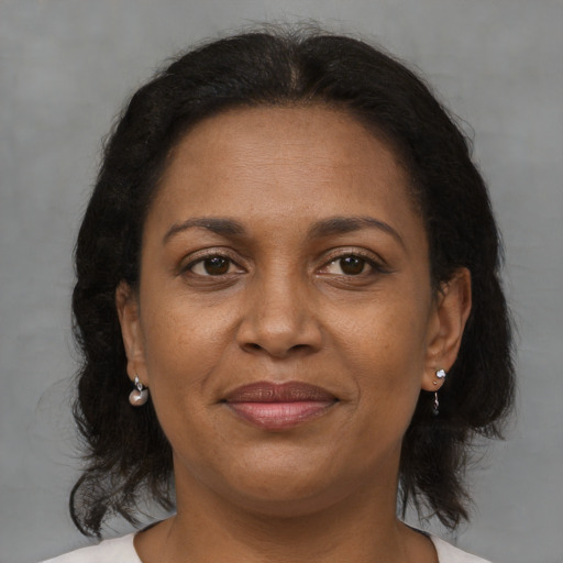 Joyful black adult female with medium  brown hair and brown eyes