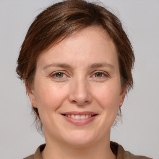 Joyful white adult female with medium  brown hair and grey eyes