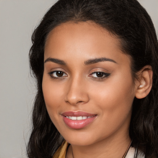 Joyful latino young-adult female with long  brown hair and brown eyes