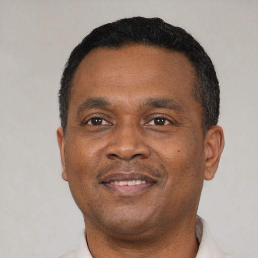 Joyful black adult male with short  black hair and brown eyes