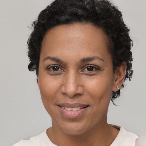 Joyful black adult female with short  brown hair and brown eyes