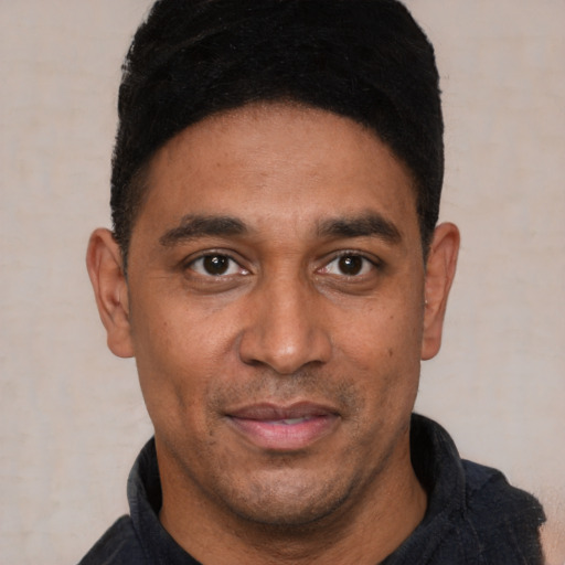 Joyful latino young-adult male with short  black hair and brown eyes