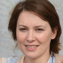 Joyful white young-adult female with medium  brown hair and blue eyes