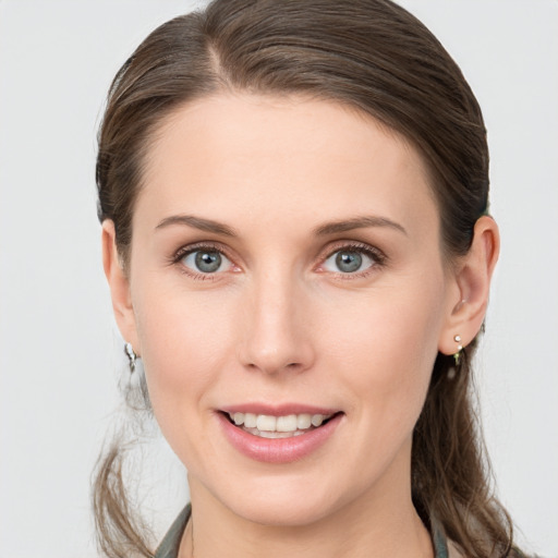 Joyful white young-adult female with medium  brown hair and grey eyes