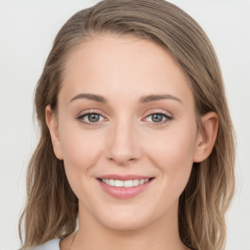 Joyful white young-adult female with medium  brown hair and grey eyes