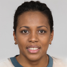 Joyful black young-adult female with short  brown hair and brown eyes