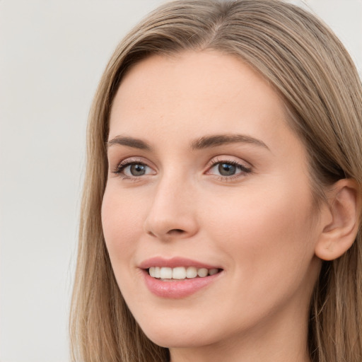 Joyful white young-adult female with long  brown hair and blue eyes