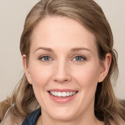 Joyful white young-adult female with long  brown hair and blue eyes