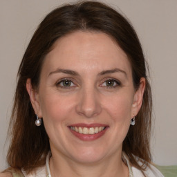 Joyful white adult female with medium  brown hair and grey eyes