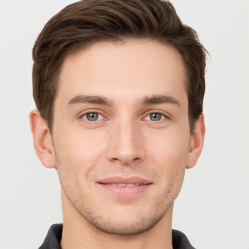 Joyful white young-adult male with short  brown hair and grey eyes