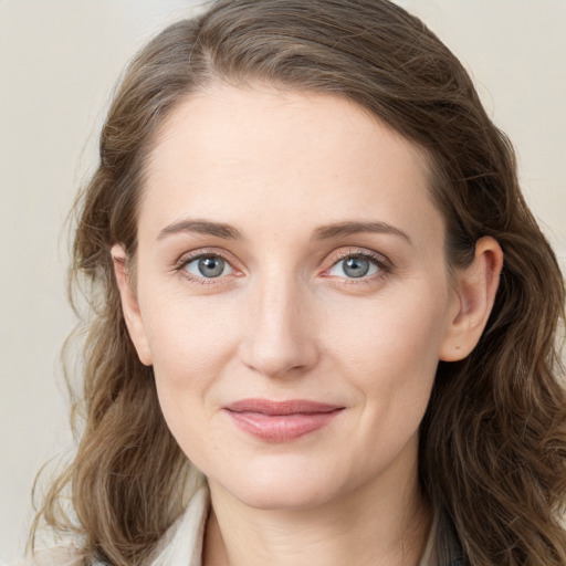 Joyful white young-adult female with long  brown hair and blue eyes