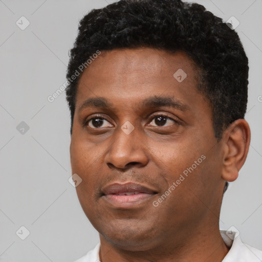 Joyful black young-adult male with short  black hair and brown eyes