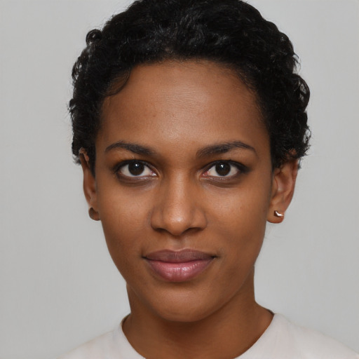 Joyful black young-adult female with short  black hair and brown eyes