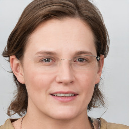 Joyful white adult female with medium  brown hair and grey eyes