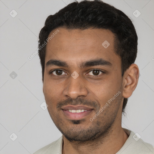 Joyful black young-adult male with short  black hair and brown eyes