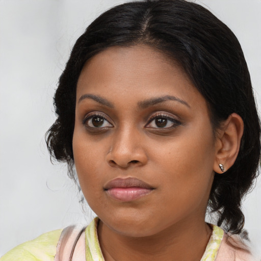 Joyful black young-adult female with medium  brown hair and brown eyes