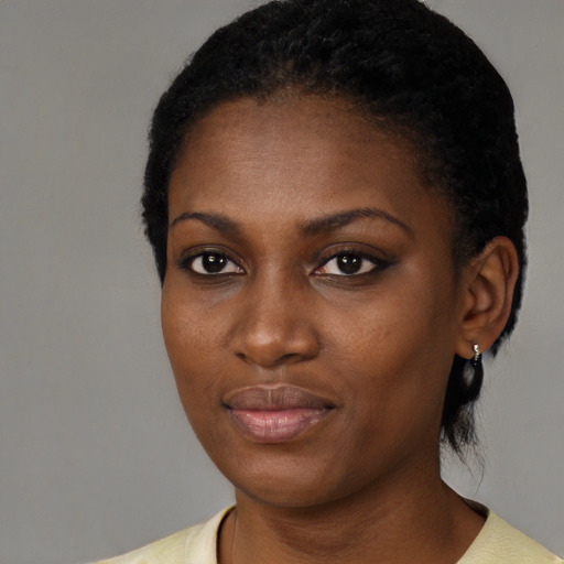 Joyful black young-adult female with short  black hair and brown eyes
