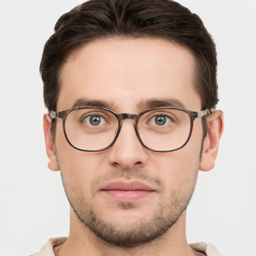 Joyful white young-adult male with short  brown hair and grey eyes