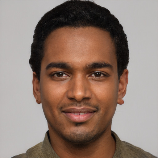 Joyful black young-adult male with short  black hair and brown eyes