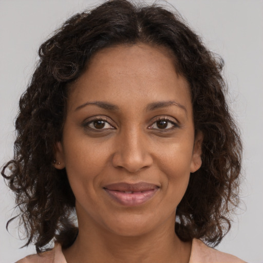 Joyful black adult female with medium  brown hair and brown eyes