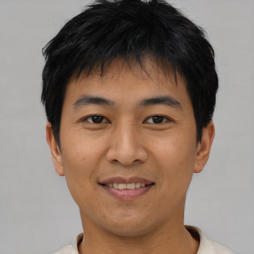 Joyful asian young-adult male with short  black hair and brown eyes