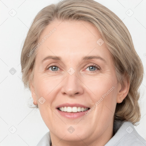 Joyful white adult female with medium  brown hair and blue eyes